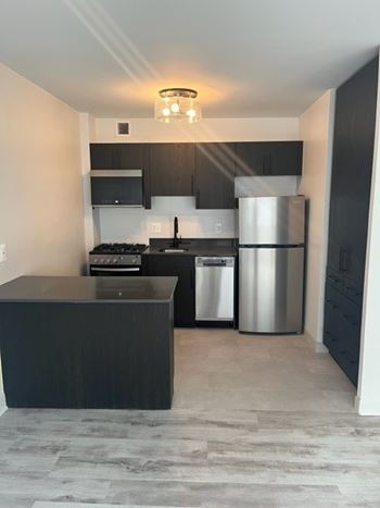 A kitchen with a black countertop and stainless steel appliances. at 2400 Pennsylvania Avenue Apartments, Washington, DC,20037